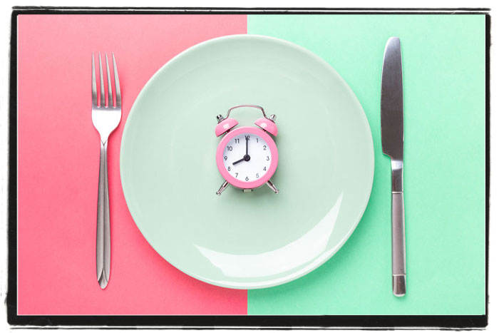 Place setting with a pink alarm clock in the center of the plate