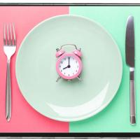 Place setting with a pink alarm clock in the center of the plate