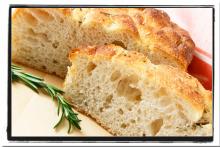 Sliced focaccia with a sprig of rosemary